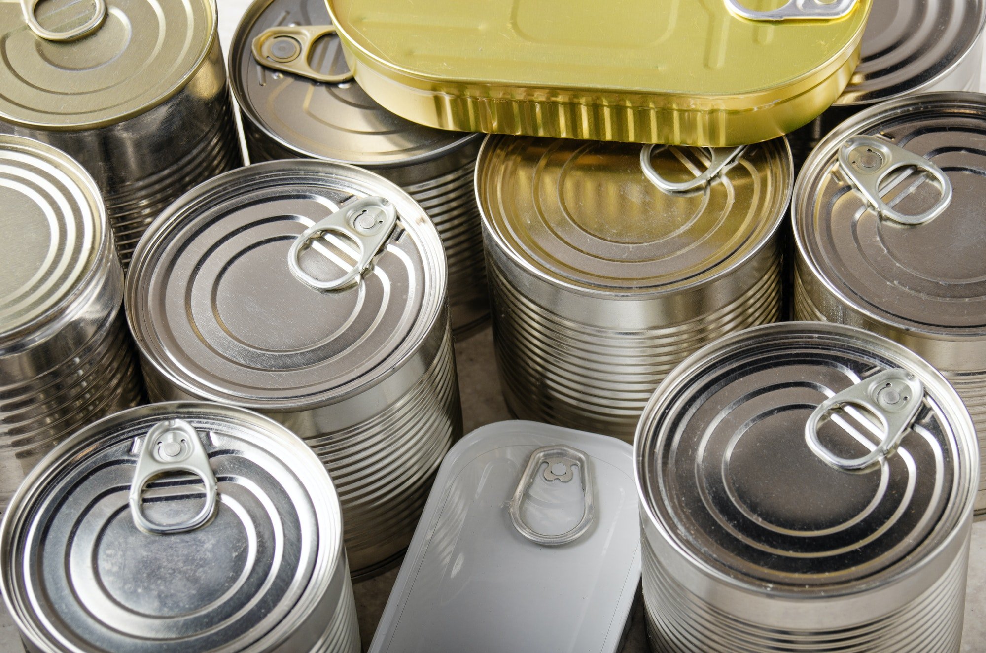 canned foods in tin cans on kitchen table